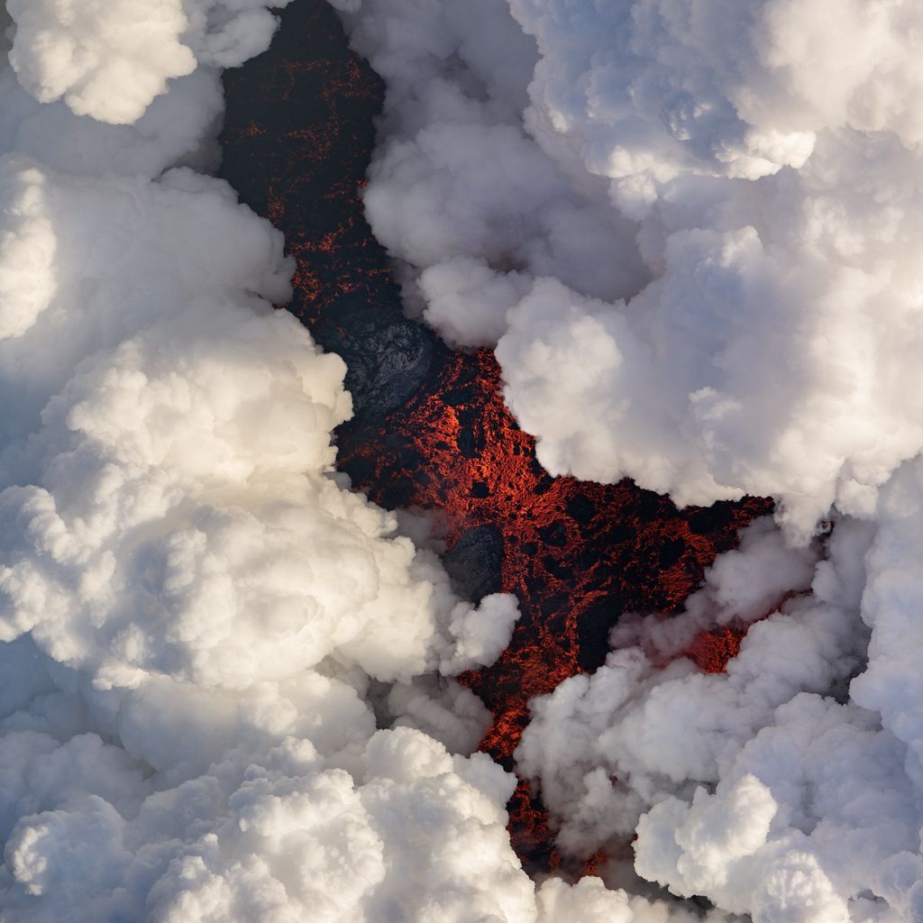 Đây là hình ảnh chụp từ trên cao vụ phun trào núi lửa Kilauea. Dung nham núi lửa sau khi chảy ra khỏi đất liền và chạm với mặt nước tạo nên những đám mây khí trắng đẹp mắt. Ảnh: Michael Perea.