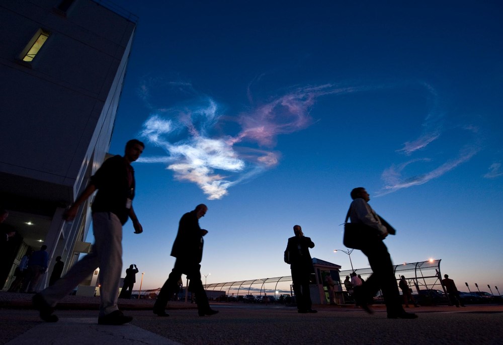 Bên dưới những đám mây chiều đầy màu sắc tại Trung tâm Điều khiển Tàu vũ trụ ở Mũi Canaveral, Florida, các nhân viên của trung tâm đang rời khỏi cơ quan sau một ngày làm việc. Lúc bấy giờ, trung tâm đang tập trung cho buổi phóng tàu coi thoi Discovery. Hình ảnh được chụp vào 05/04/2010.