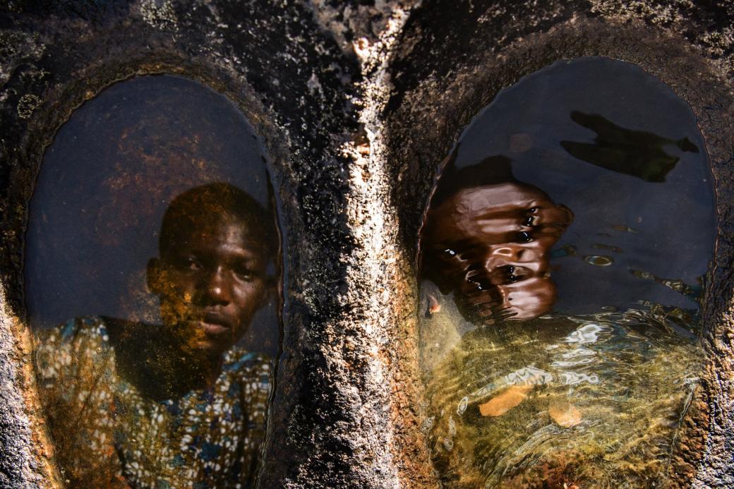 Với 100 ca sinh đôi trên 1.000 ca sinh thường, người Yorubae có tỷ lệ sinh đôi cao nhất thế giới. Trong ảnh là anh em Kehinde Quadrat và Taiwo Badrat (17 tuổi) đang cùng nhau nhìn vào mặt nước giếng.