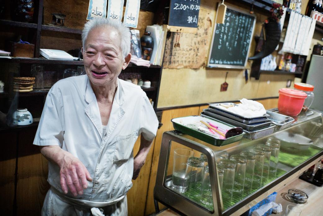 Quán rượu 50 năm tuổi của cụ ông 74 tuổi tại Shinjuku hiện mở cửa sáu ngày mỗi tuần và tám giờ mỗi ngày. Ngoài thời gian buôn bán, công việc chủ yếu của ông là nở nụ cười tươi vui với khách hàng.