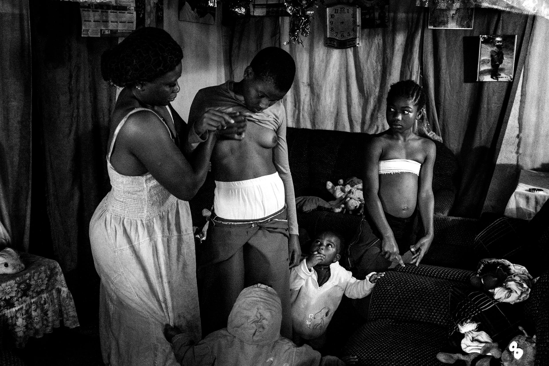 Giải nhất hạng mục Đương đại. Veronica 28 tuổi, đang nén ép ngực của con gái 10 tuổ của mình là bé Michelle. Người mẹ đang thực hiện một phương pháp truyền thống của người dân Cameroon, việc ép ngực khiến nó không thể phát triển, qua đó làm chậm sự trưởng thành và giúp bé gái tránh khỏi nạn hiếp dâm. Ảnh: Heba Khamis/Handout/EPA.