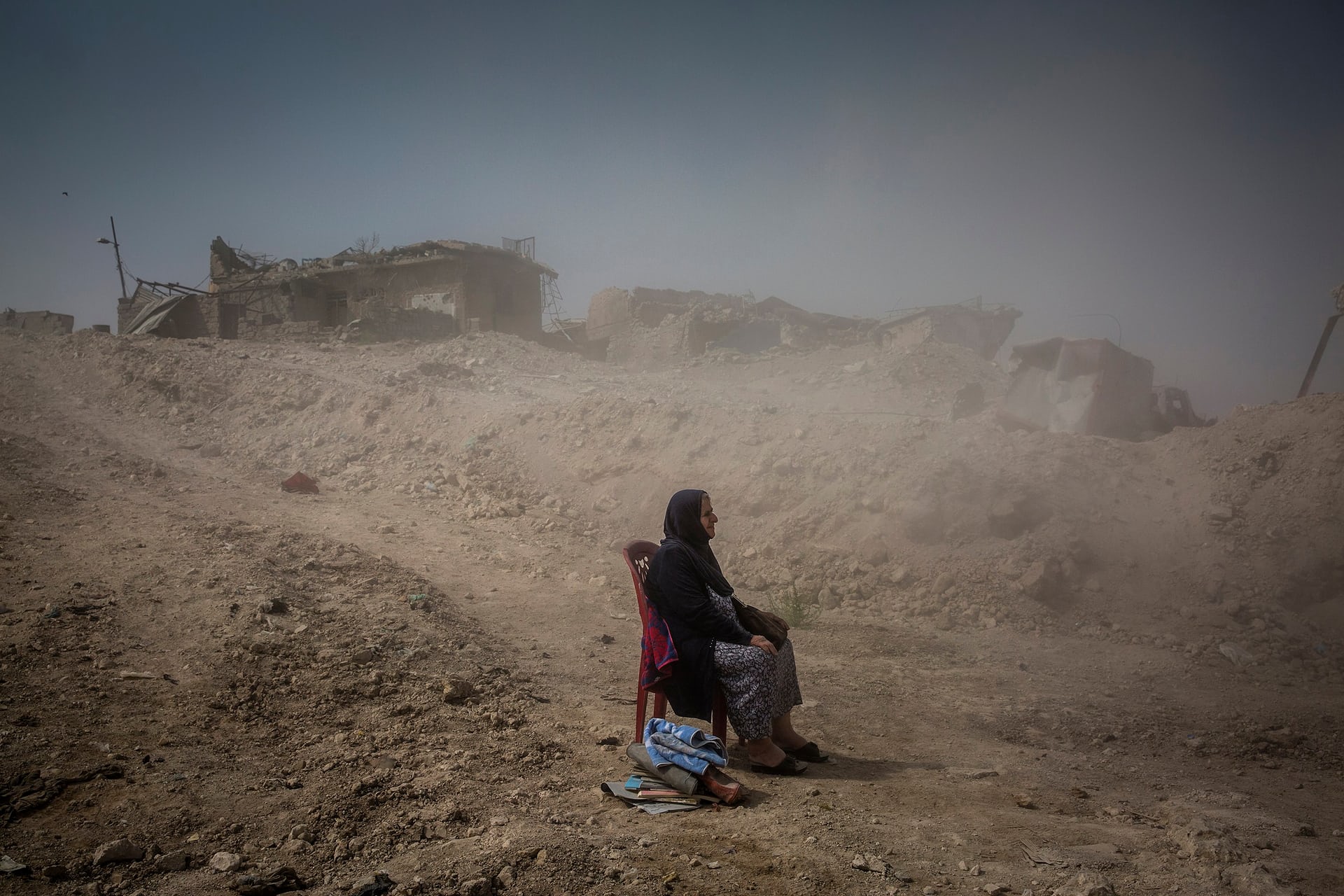 3000 6Giải nhất hạng mục Tin tức. Bà Nadhira Aziz đang ngồi quan sát những công binh của quân đội Iraq chôn xác em gái và cháu gái của của bà tại thành phố Mosul. Trước đó, thành phố này chứng kiến một cuộc không kích dữ dội vào tháng 6 khiến hơn 9.000 dân thường thiệt mạng. Ảnh: Ivor Prickett/New York Times/Handout/EPA.