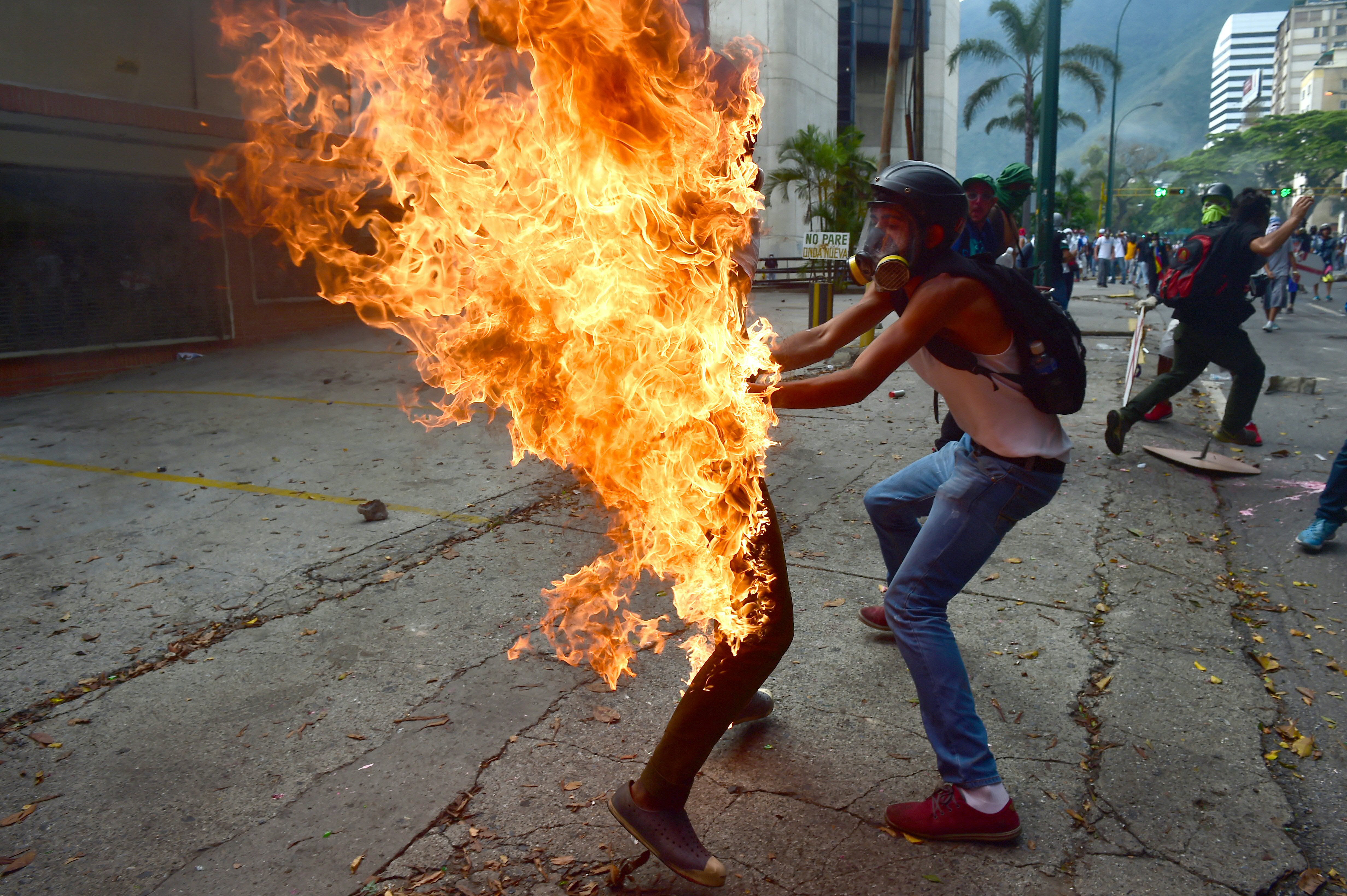 Những người tham gia biểu tình đã kịp thời dập lửa cho José Víctor Salazar Balza. Ảnh: Ronaldo Schemidt/AFP/Getty Images.