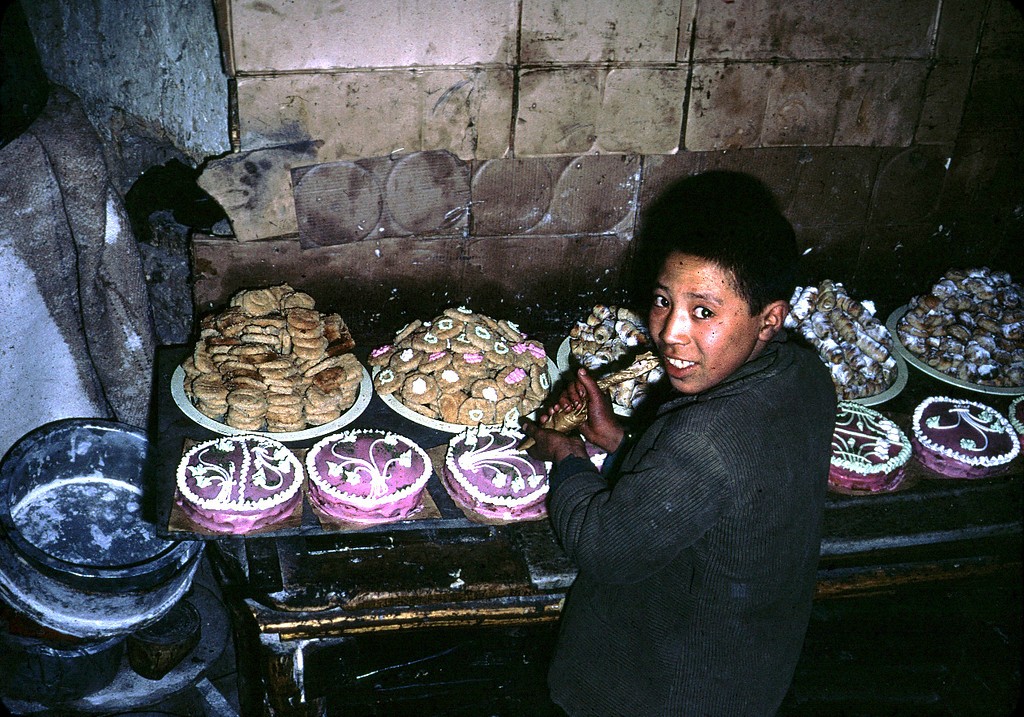an afghan boy decorates cakes