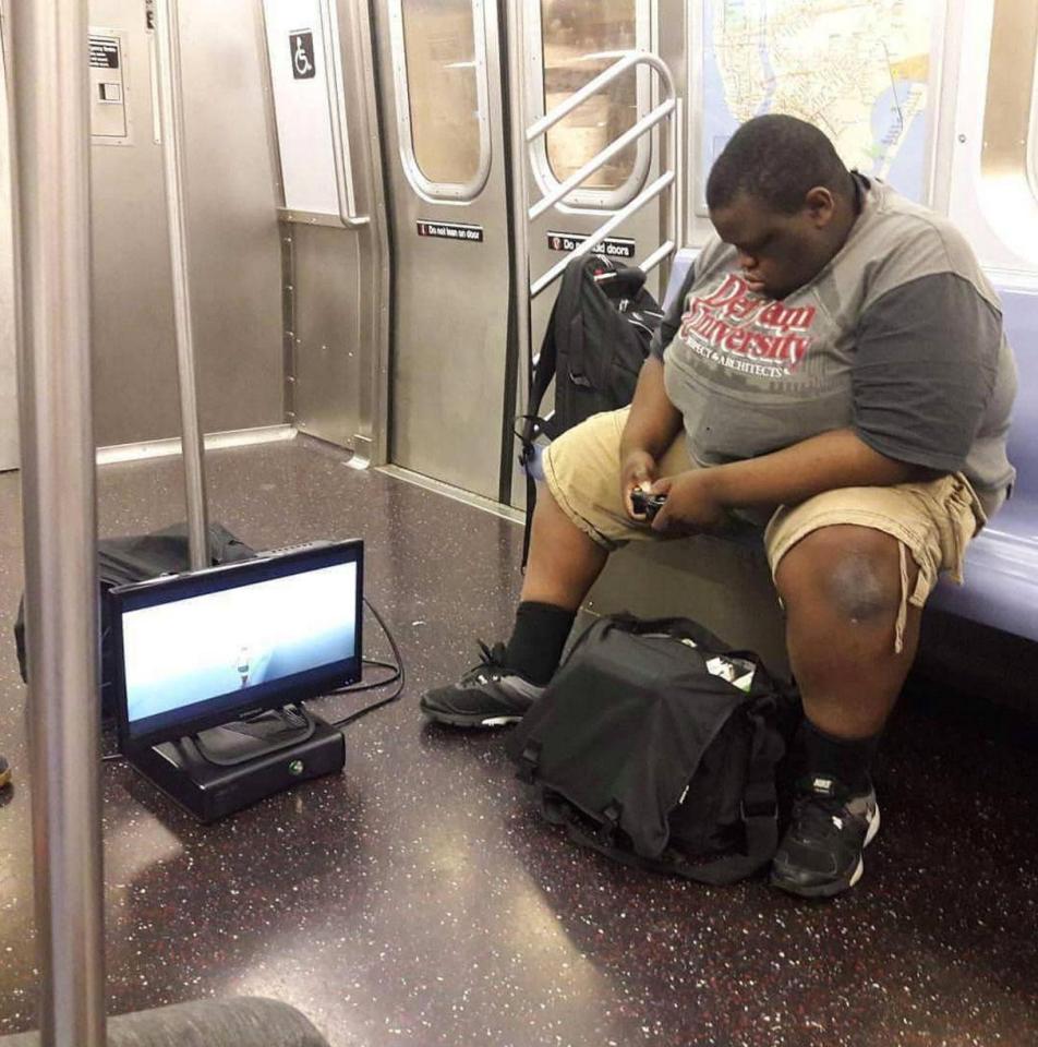 a man playing xbox on train
