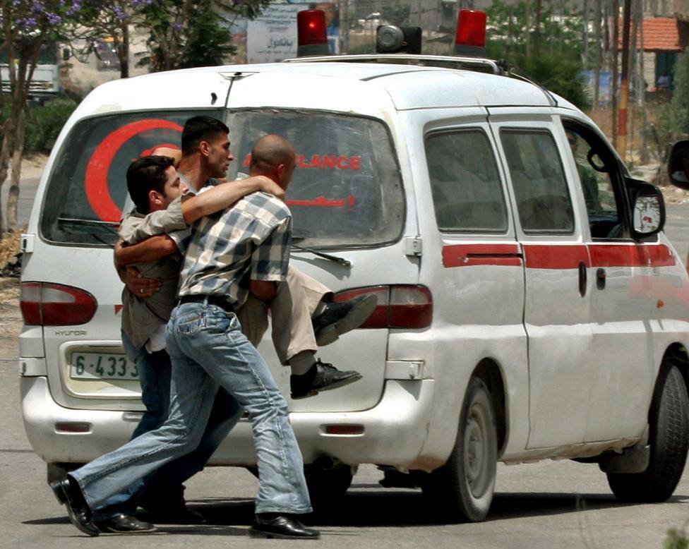 palestinians carry a cameraman