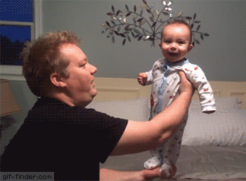 balancing baby laughing with dad