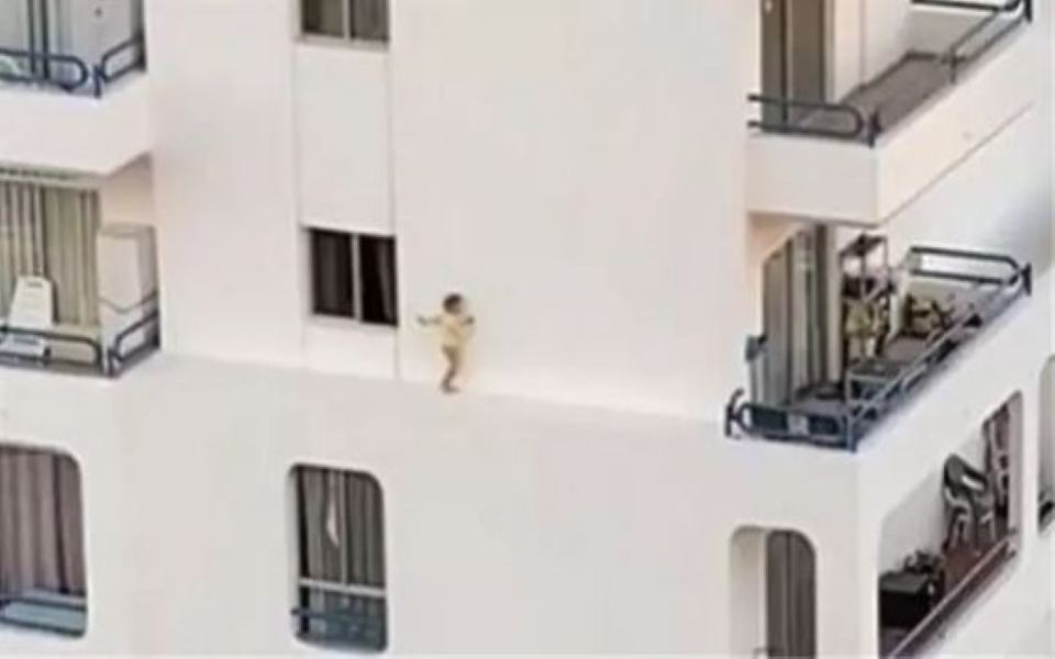 Video rợn người: Bé gái chạy trên gờ đá ngoài ban công khách sạn