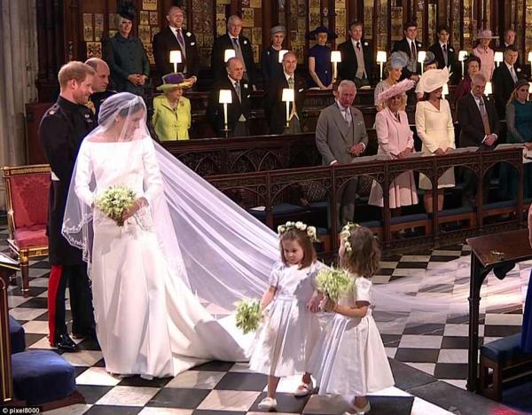 when meghan appeared through the doors of the chapel sunlight streaming in behind her she turned to smile and wave at the children who were standing to her right behind the door