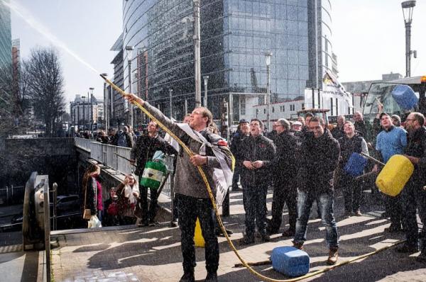 a young farmer is spraying milk on a building of the european commission during a protest in brussels