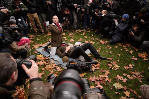 demonstrators take part in a mass face sitting protest outside the houses of parliament in central london on december