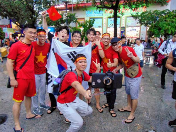 Trận bóng kết thúc với phần thắng thuộc về đội tuyển Hàn Quốc. Người hâm mộ Việt Nam chia sẻ niềm vui cùng các du khách người Hàn.
