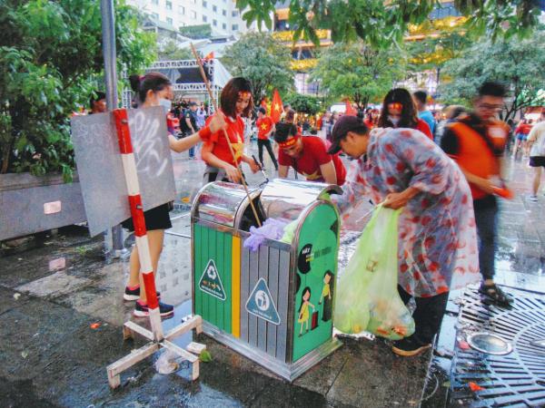 Cổ động viên nán lại để dọn dẹp rác ở Phố đi bộ Nguyễn Huệ trước khi ra về.
