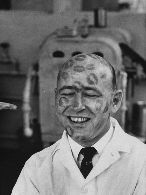 worker in cosmetic company covered with relics of lipstick kisses to prove that dyes in lipsticks are harmless 1960