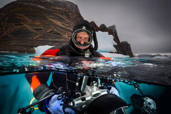 David Doubilet, tác giả của bộ ảnh trên, đang chụp hình bản thân trong một chuyến lặn biển ở gần Đảo Red, Vịnh Scoresbysund, phía đông Greenland. Ảnh: David Doubilet/National Geographic.