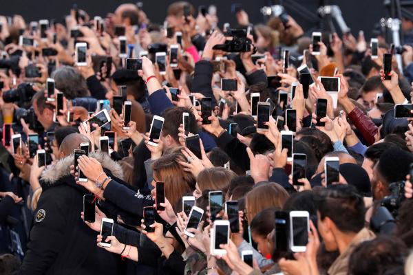 Người tham dự buổi trình diễn thời trang L'Oreal ở Đại lộ Champs Elysees sử dụng điện thoại thông minh để chụp hình, trong khuôn khổ Tuần lễ Thời trang Paris tại Pháp vào 10/2017. Ảnh: Charles Platiau/Reuters.