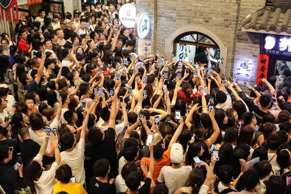 Người âm mộ sử dụng điện thoại để ghi hình buổi trình diễn ca nhạc của nhóm nhạc Modern Brothers tại Phố cổ An Đông, thành phố Đan Đông, tỉnh Liêu Ninh, Trung Quốc. Nhóm nhạc Modern Brothers có hơn 20 triệu người hâm hộ trên TikTok, một nền tảng mạng xã hội video rất phổ biến ở Trung Quốc. Ảnh: VCG/Getty.