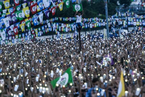 Những người ủng hộ Selahattin Demirtaş, ứng cử viên tổng thống bị bỏ tù của Đảng Dân chủ Nhân dân (HDP), đang cầm đảng kỳ của HDP cùng điện thoại bật đèn sáng để tham gia chiến dịch bầu cử ở Istanbul, Thổ Nhĩ Kỳ, vào 17/06/2018. Ảnh: Yasin Akgul/AFP/Getty.