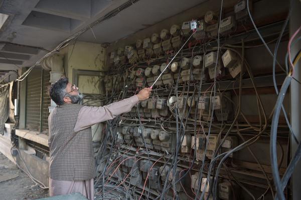 Muhammad Noshad, một nhân viên của Công ty Cung cấp Điện năng Islamabad (IESCO) thuộc chính phủ Pakistan, đang đọc số công tơ mét điện tại một trung tâm thương mại ở Islamabad. Noshad là nhân viên lâu năm của IESCO, ông đã làm việc ở đây suốt 23 năm qua. Ông cho biết điện thoại thông minh ảnh hưởng đáng kể đến công việc của mình. Giờ đây ông có thể dễ dàng ghi lại số điện của đồng hồ điện và lưu trữ thông tin khách hàng qua điện thoại. Ảnh: Aamir Qureshi/AFP/Getty.