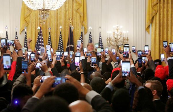 Trong khuôn khổ Hội nghị thượng đỉnh Lãnh đạo trẻ Da màu diễn ra ở Phòng Đông của Nhà Trắng, những người tham dự sử dụng điện thoại để chụp ảnh va quay phim Tổng thống Donald Trump khi ông đang phát biểu. Ảnh: Cathal McNaughton/Reuters.