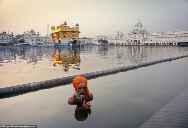 7377426 6491533 a sikh pilgrim performs his washing ritual in the lake in amrits a 7 1544860826865
