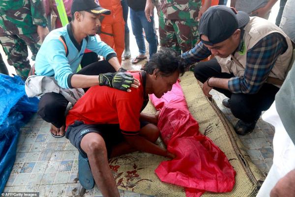 7759010 6524553 a man grieves beside the body of his child in south lampung on s a 26 1545573610432