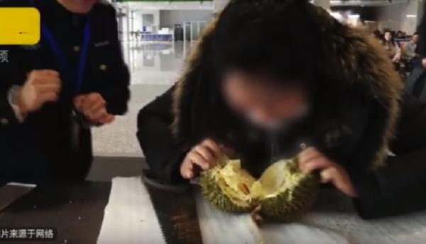 a woman eat a durian at railway station 1