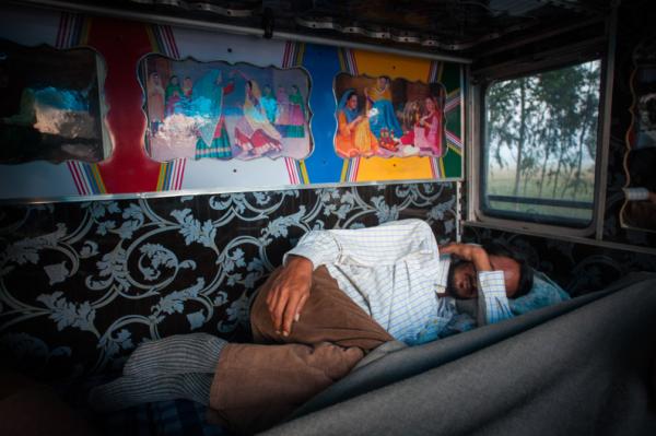 Avtar Singh ngủ trong cabin xe tải sau chuyến đi dài xuyên đêm băng qua con đường kém an toàn tại bang Haryana. Cung đường này ngoài hạ tầng giao thông kém, nó còn là nỗi sợ cho cánh tài xế bởi những băng cướp xe tải chuyên nghiệp. Phần lớn thời gian của chuyến đi, các bác tài gói mình vào không gian chật hẹp của cabin.
