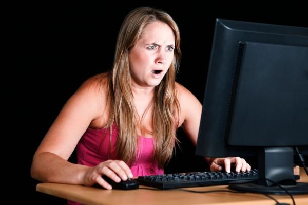 1 pretty blonde stares shocked and disbelieving at computer monitor