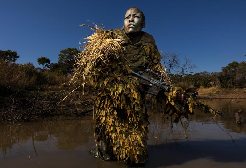 Petronella Chigumbura (30 tuổi), thành viên của đơn vị kiểm lâm hoàn toàn là phụ nữ đang tham gia khóa huấn luyện hóa trang và ẩn thân tại Công viên Quốc gia Phundundu, Zimbabwe. Ảnh: Brent Stirton.