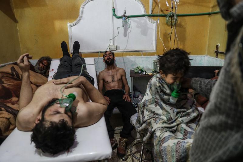 Một người đàn ông và một đứa trẻ đang thở bằng máy và được điều trị sau cuộc tấn công bằng khí độc sinh học ở al-Shifunieh, Đông Ghouta, Syria. Ảnh: Mohammed Badra.