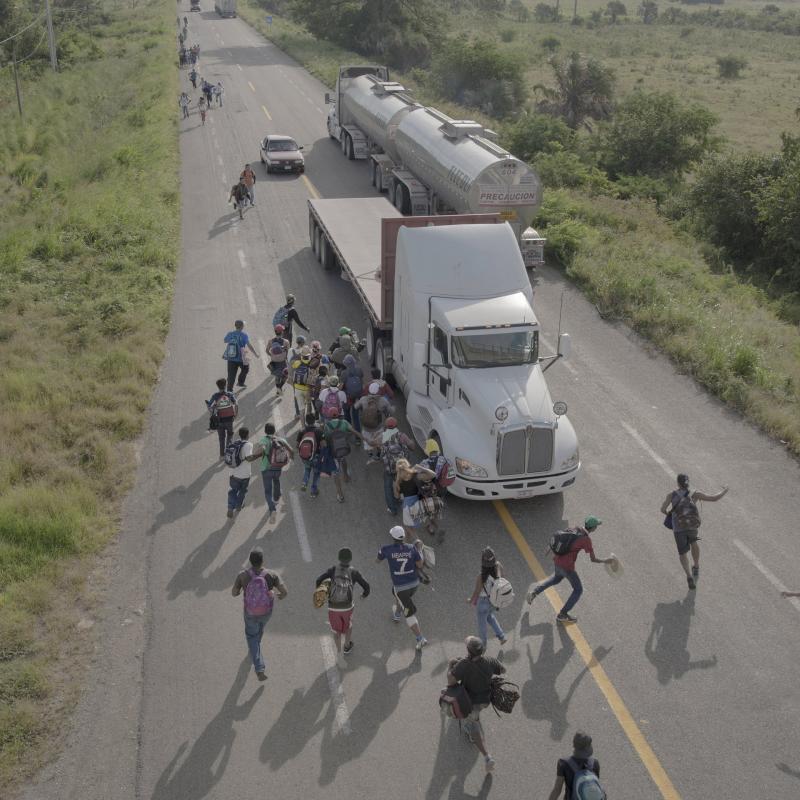 Những người di cư chạy ra giữa đường để chặn một chiếc xe tải rồi xin đi nhờ tại Tapanatepec, Mexico. Cánh tài xế chạy tuyến đường từ Mexico đến biên giới Mỹ thường xuyên gặp tình huống như thế này và họ thường cho đi nhờ miễn phí.