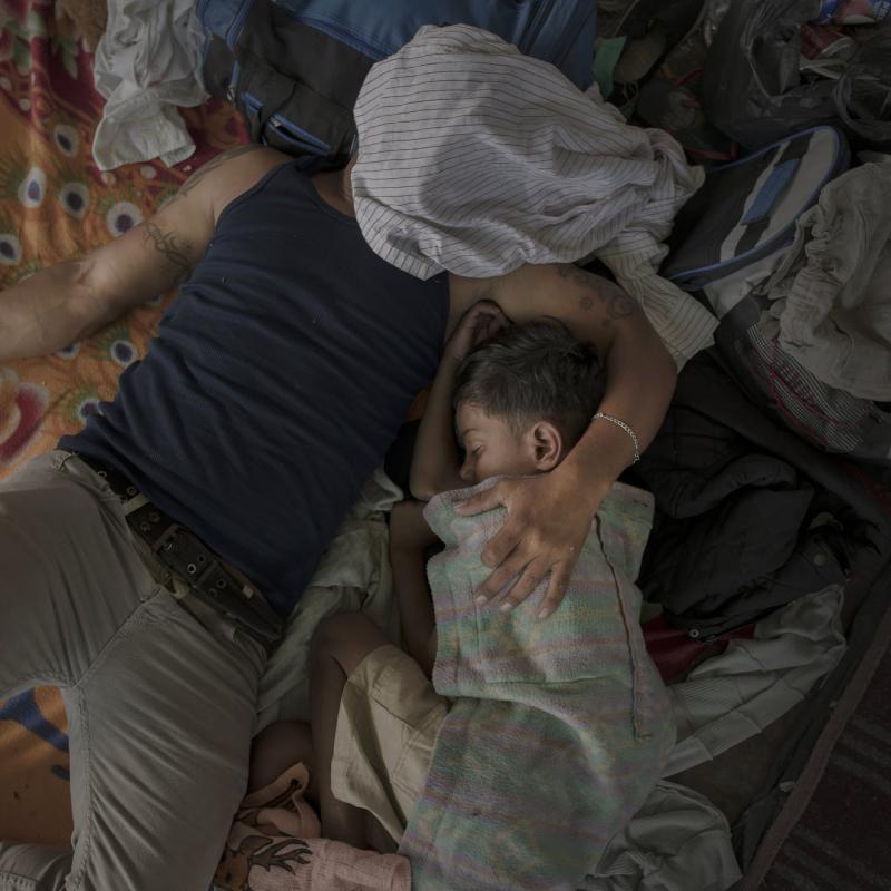 Người cha cùng cậu con trai của mình đang ngủ thật ngon sau một ngày dài đi bộ cùng dòng di dân tại Juchitán, Mexico.