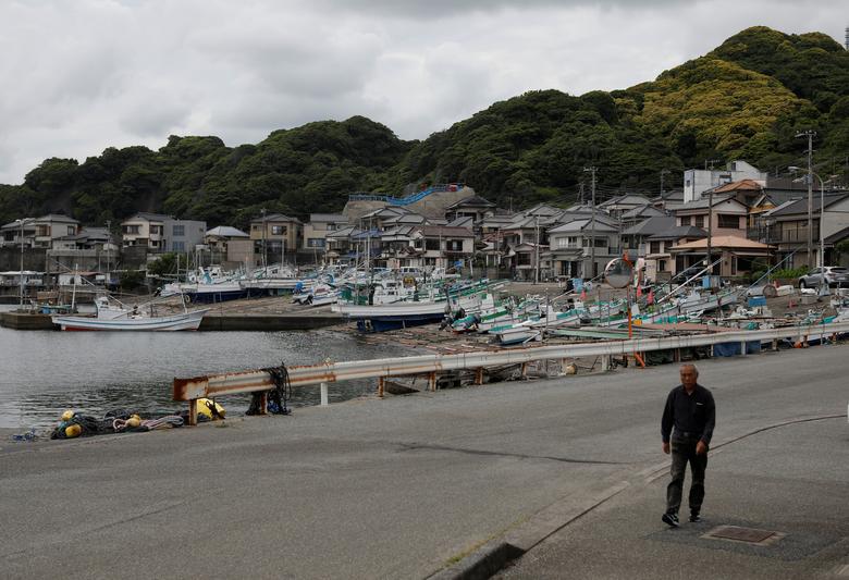 Một người đàn ông bước đi tại cảng cá Minamiboso, nơi có làng nghề đánh bắt cá voi lâu đời nhất Nhật Bản.