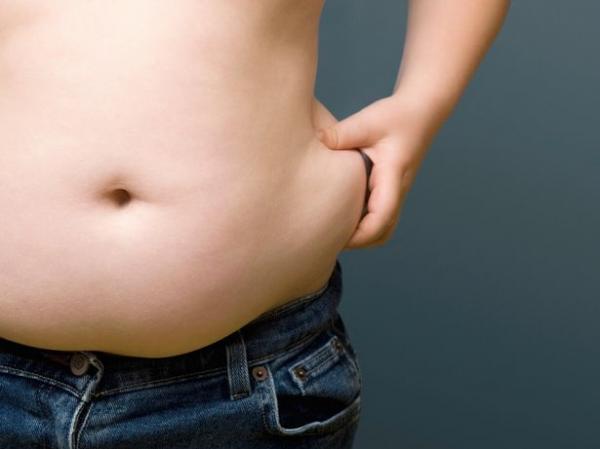 0 overweight boy aged 6 8 pinching fat around his waist